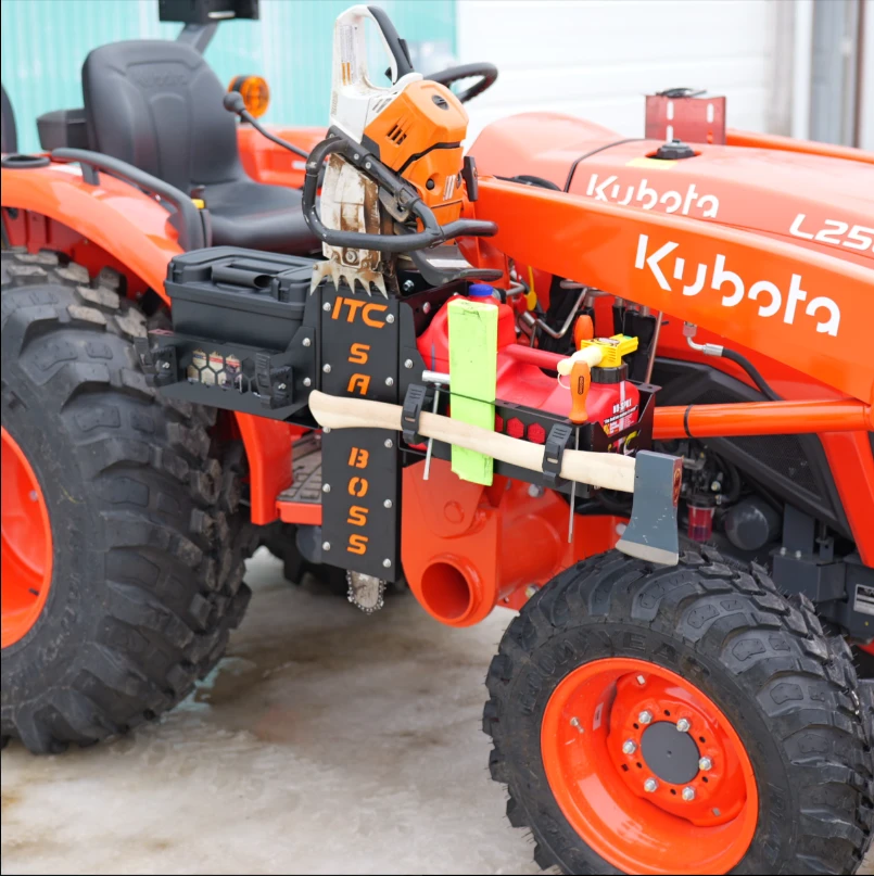 ITC Saw Boss carrier loaded with a chainsaw and axe, mounted on an orange Kubota tractor